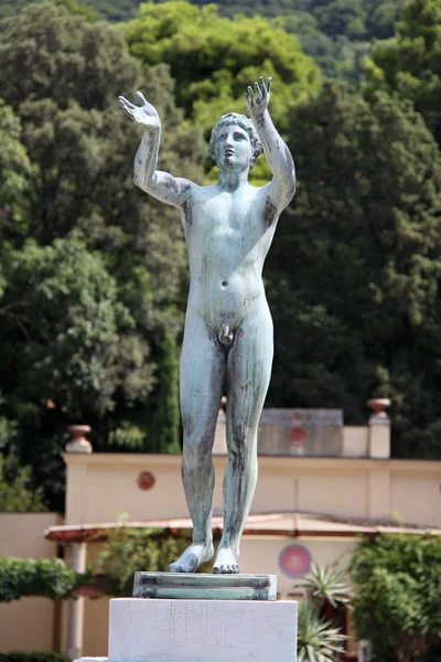 Statue of the naked man with wide open arms