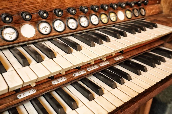Teclado de piano duplo antigo com teclas marcadas e puxa detalhes — Fotografia de Stock