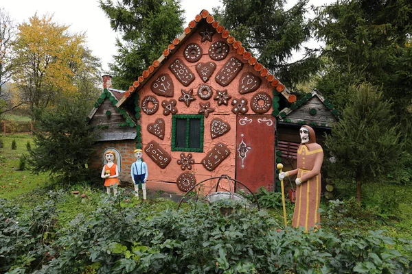 Fairy tale house covered with sweets and Jack and Jill with witch — Stock Photo, Image