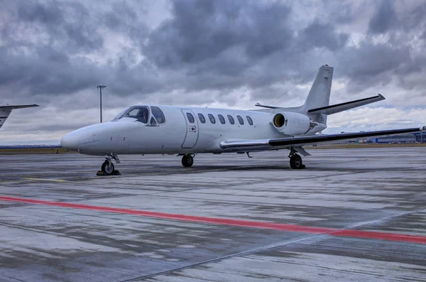 Alter kleiner weißer Business-Jet auf der Rampe unter wolkenverhangenem Himmel — Stockfoto