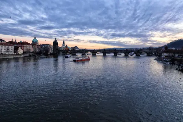 Charles bridge en rivier Vltava met sommige boten in de avond — Stockfoto