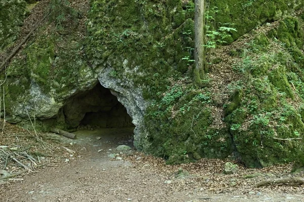 Liten grotta ingången hålet i mossa täckt rock — Stockfoto