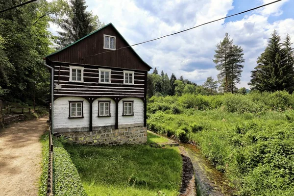 Casa de madeira junto ao pequeno riacho — Fotografia de Stock