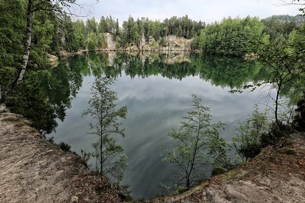 Lago entre rochas arenosas cobertas por floresta — Fotografia de Stock