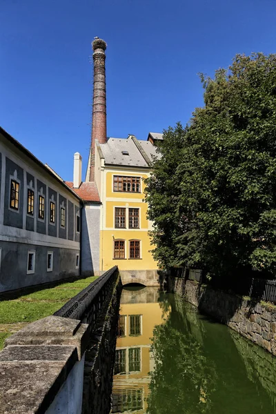 Žlutá továrna s vysoký komín a vodní mlýn závod — Stock fotografie