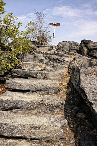 Steinerne Stufen den Hügel hinauf mit Schilderkreuz — Stockfoto