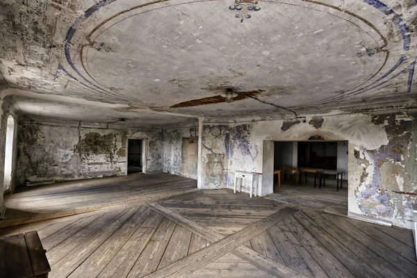 Grande sala vazia com piso de madeira e teto rachado — Fotografia de Stock