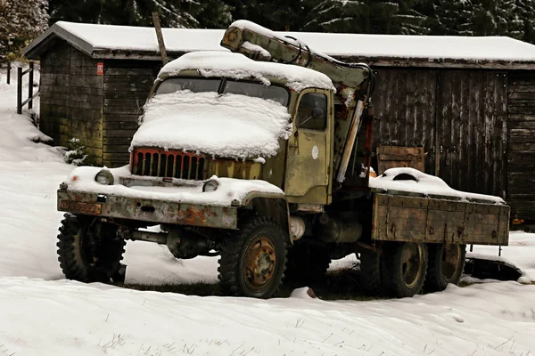 Old unused off-road truck covered with snow