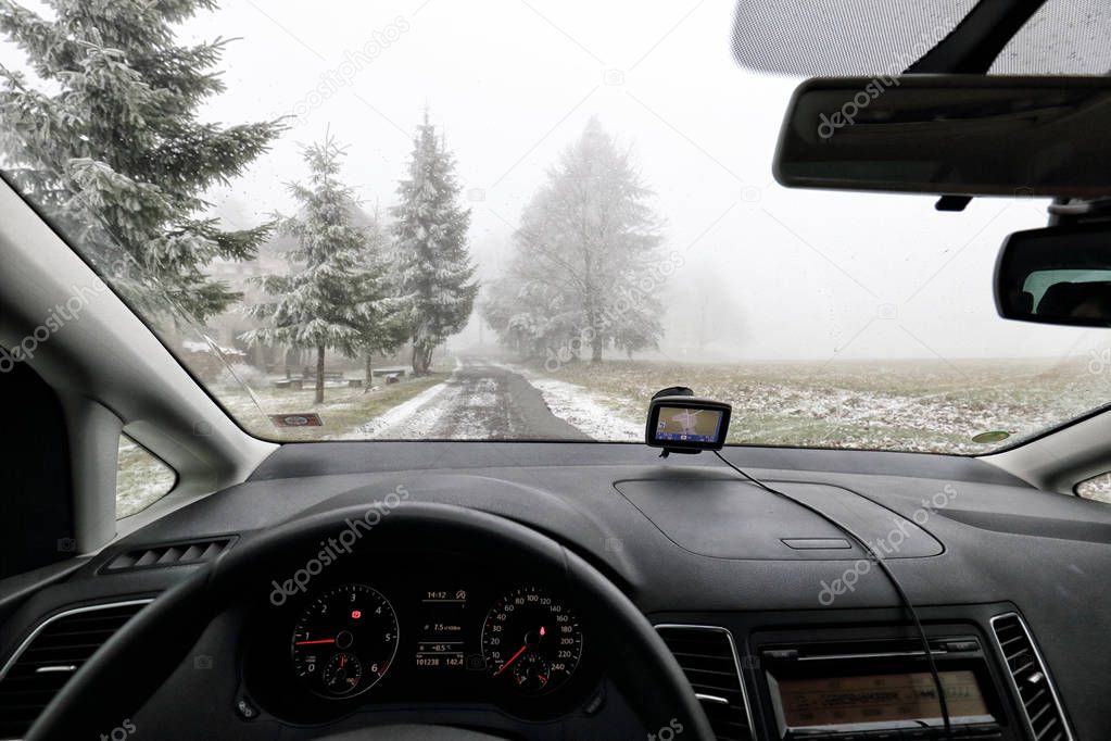 Dashboard of the car on the foggy snow covered road