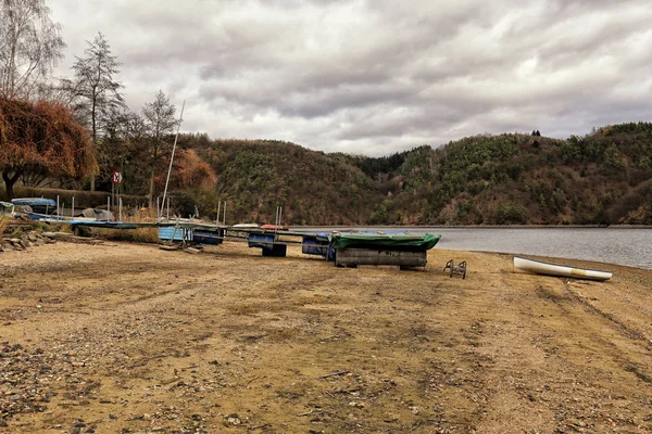 Let-out margem do lago com barco e toupeira deitado na areia — Fotografia de Stock