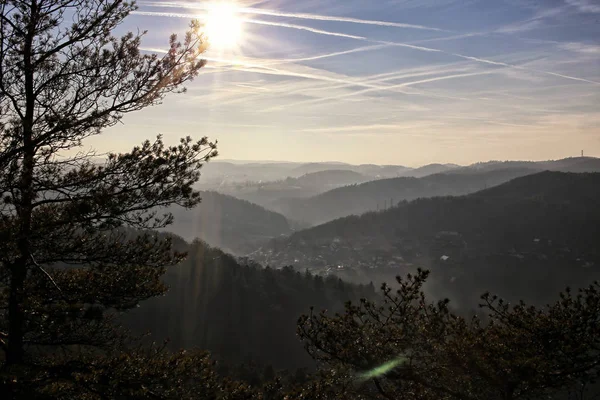 Panorama com colinas no nevoeiro de luz contra o sol — Fotografia de Stock