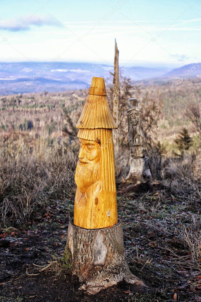 Wooden figure of the forest spirit on the old stump