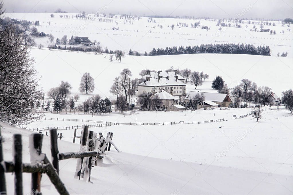 Snow covered countryside panorama with some white houses