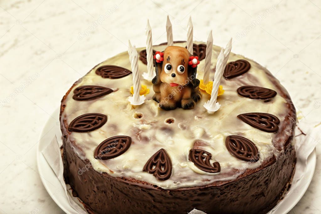 Chocolate cake with ornaments and little female puppy marzipan figure with eight candes