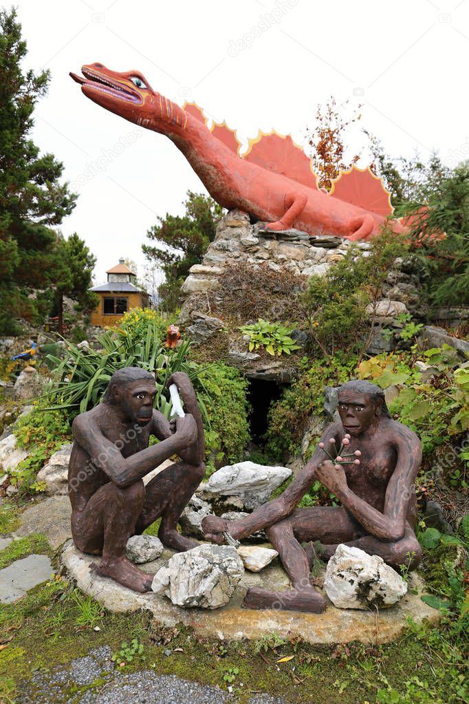 Large prehistoric dinosaur on the rock and primeval men