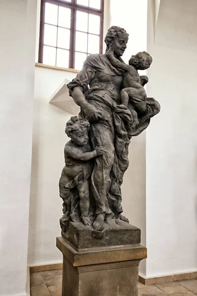 Статуя женщины, держащей ребенка со вторым ребенком за ногу — стоковое фото