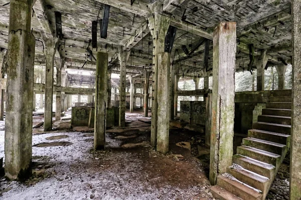 Interior of the abandoned factory building with stairs and metal rods by ceiling — Stock Photo, Image