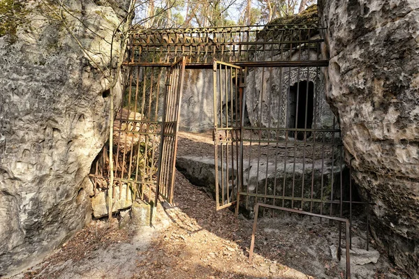 Kayalar arasında açık kanatlı eski metal kapı — Stok fotoğraf