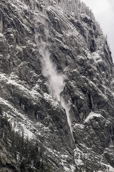 Pequena avalanche entre árvores em rocha íngreme — Fotografia de Stock