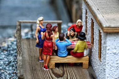 Ahşap terace üzerinde oturan insanlar grup küçük bir model