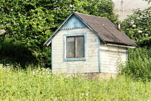 Pequena casa de jardim branco abandonado com janela única — Fotografia de Stock
