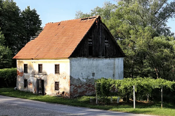 Öreg ház repedt homlokzattal és törött tetővel — Stock Fotó