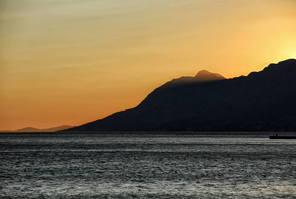 Luz tardía por la noche junto al mar con cielo naranja — Foto de Stock