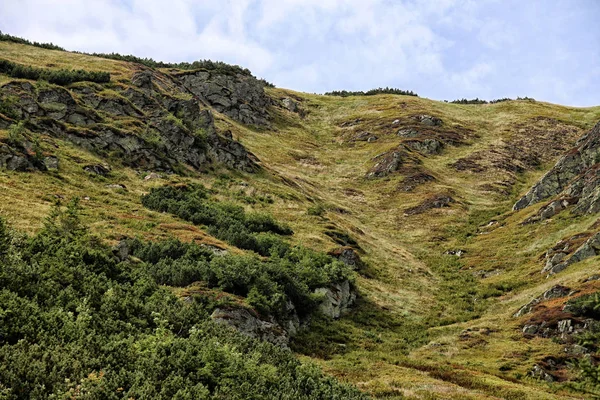 Encosta de montanha íngreme com grama e pedras — Fotografia de Stock
