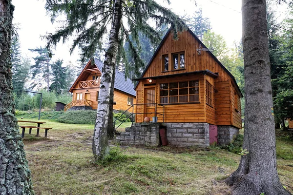 Pareja de cabañas de madera con porche cubierto —  Fotos de Stock