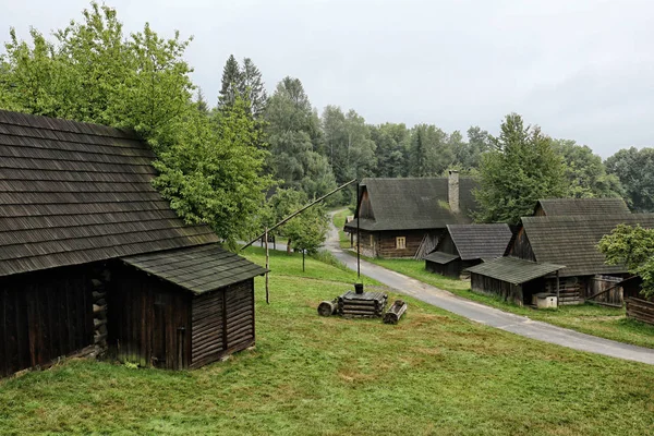 Historické dřevěné chaty s asfaltovou silnicí a zelenými trávníky — Stock fotografie