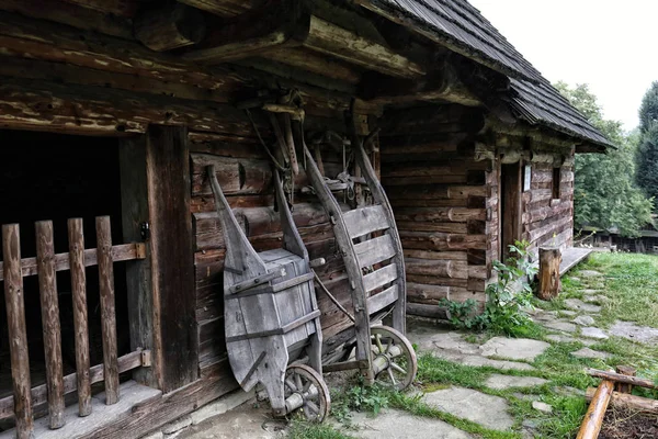 Pair of old wooden wheel barrows by the wooden cottage — Stock Photo, Image