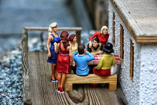 Ahşap terace üzerinde oturan insanlar grup küçük bir model