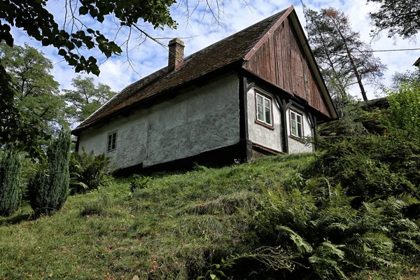 Liten Chalet med trä gavel på toppen av gräsbevuxen Hill — Stockfoto