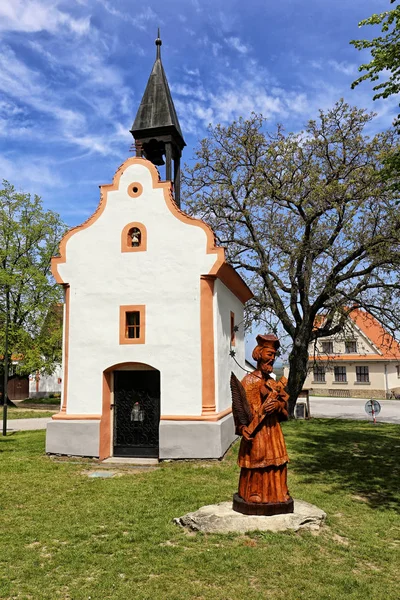 村の礼拝堂の横に十字架を持つ聖人の木像 — ストック写真