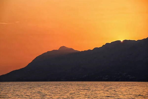 Silueta de la montaña por la puesta de sol naranja — Foto de Stock