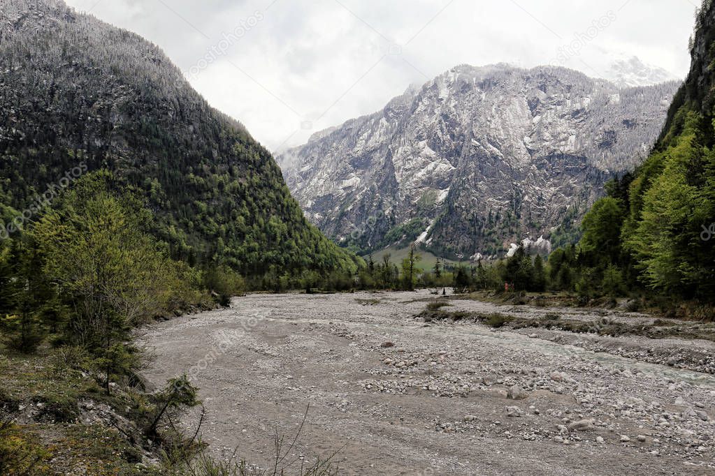 Wide almost empty river-bed full of gravel