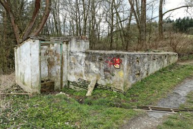 Yol kenarında kuru tuvalet olan mezarlığın kalıntıları.