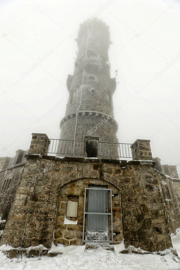 Decinsky-sneznik outlook tower in the winter time with fog and snow