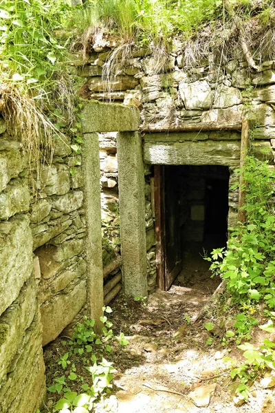 Hidden door portal of old ruined stony house cellar