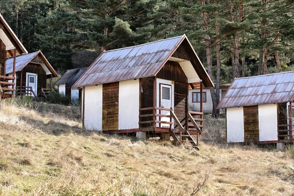 Small wooden cotage camp on the grassy hill off season