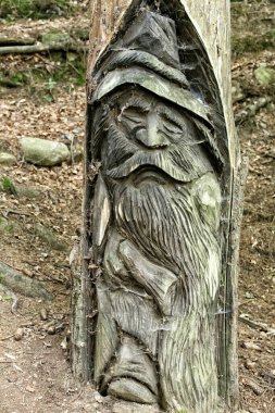 Ağaç gövdesi kesilmiş, şapkalı, uzun bıyıklı tahta cüce.