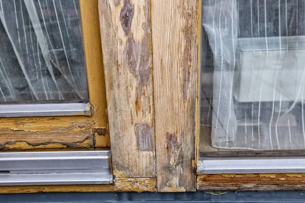 Window frame with peeled and damaged  brown color cover