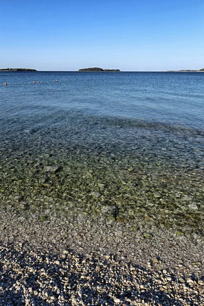 Morze Przy Pustej Plaży Żwirem Czystą Wodą Wyspą Horyzoncie Słoneczny — Zdjęcie stockowe