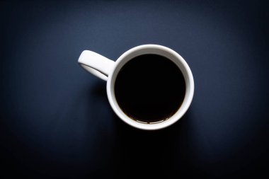 Koyu mavi arka planda kahve fincanı..