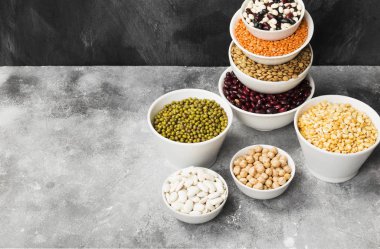 Fasulye ürün yelpazesine (kırmızı mercimek, yeşil mercimek, nohut, bezelye, Kuru fasulye, fasulye, mix fasulye, mung fasulye) gri arka plan üzerinde. Görünümü en çok, uzay kopyalayın. Gıda arka plan