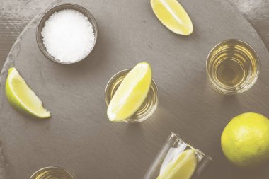 Tekila limon ve tuz karanlık bir arka plan üzerinde. Üstten Görünüm. Gıda arka plan. Tonda