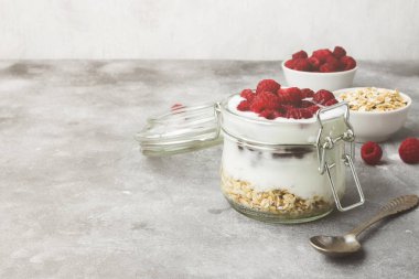 Glanola cam ahududu üzerinde gri bir arka plan ile. Uzay kopyalayın. Gıda arka plan. Tonda