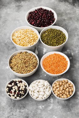 Fasulye ürün yelpazesine (kırmızı mercimek, yeşil mercimek, nohut, bezelye, Kuru fasulye, fasulye, mix fasulye, mung fasulye) gri arka plan üzerinde