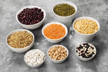 Fasulye ürün yelpazesine (kırmızı mercimek, yeşil mercimek, nohut, bezelye, Kuru fasulye, fasulye, mix fasulye, mung fasulye) gri arka plan üzerinde