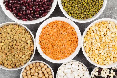 Fasulye ürün yelpazesine (kırmızı mercimek, yeşil mercimek, nohut, bezelye, Kuru fasulye, fasulye, mix fasulye, mung fasulye) gri arka plan üzerinde. Üstten görünüm. Gıda arka plan